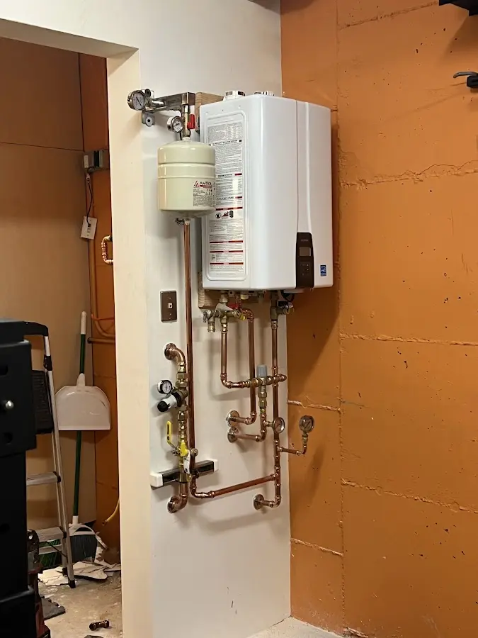 Plumbing technician inspecting water heater connections in Benton City
